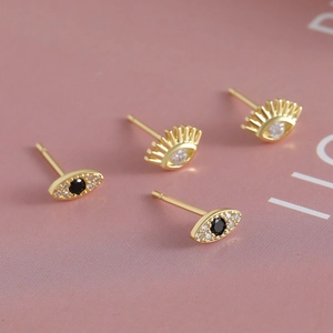 18k gold plated evil eye stud earrings with cubic zirconia on soft pink background