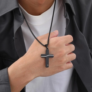 Close-up of black stainless steel cracked cross necklace with a small inlaid crystal
