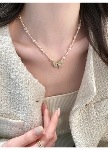 Elegante Franse vintage parelketting met een glinsterende strik van zirkoon op model