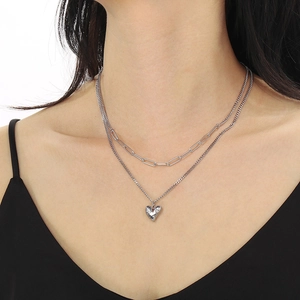 Détail du collier double rang avec pendentif cœur argenté porté par un mannequin