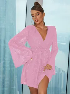 Dettaglio mini abito con paillettes rosa acceso con scollo a V profondo e maniche a campana