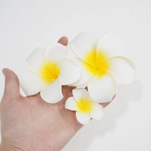 Detailed size comparison of three foam plumeria flower clips held in a hand