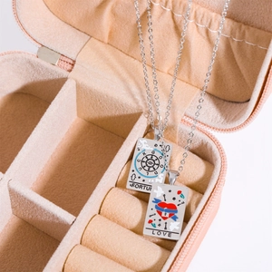 Detail view of silver tarot necklaces with Luck and Love charms in a pink velvet jewelry box