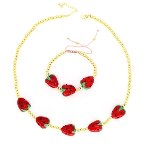 Detailed view of beaded strawberry necklace and bracelet set on a white background