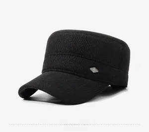 Detail view of the black flat top military cap featuring a textured fabric and metal side logo