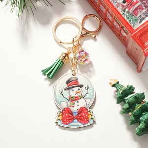 Détail du porte-clés bonhomme de neige avec pompon vert et paillettes étoilées