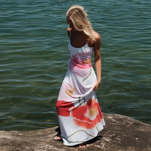 Floral print maxi dress with U-neck and open back design on a scenic outdoor background