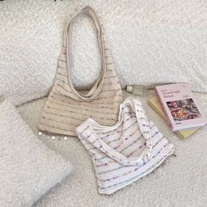 Detail of crochet knit tote bag with rainbow stripes, shell charms and metallic discs