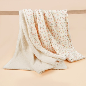 Detailed view of thick muslin baby blanket with floral print and soft sherpa lining