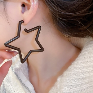 Close-up of a model wearing large black hollow star-shaped acrylic stud earrings