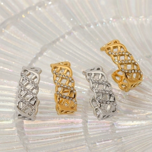 Elegant gold and silver hollow lattice rings with sparkling crystals in a shell dish