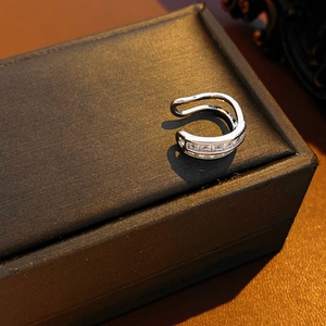 Close-up of silver double-layer ear cuff with square-cut zircons on a jewelry box