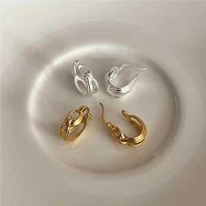 Detailed view of handmade knotted silver stud earrings in gold and silver finish