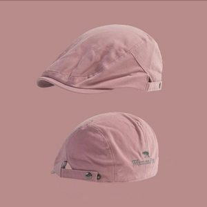 Detail view of pink cotton beret showing the side buckle and brand logo embroidery