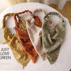 Flat lay detail of four floral chiffon headscarves with elastic bands in assorted colors
