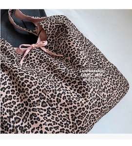 Close-up of leopard print canvas tote bag featuring pink lining and decorative bow tie