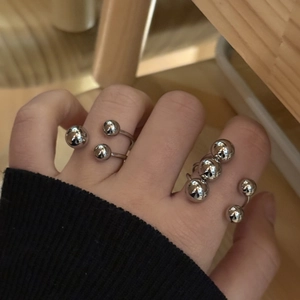 Modern polished stainless steel spherical rings set in minimalist silver open style
