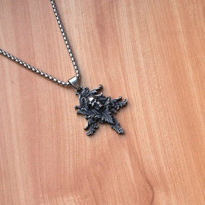 Dettaglio del ciondolo a teschio gotico con decorazioni floreali su legno