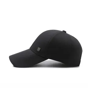 Détail d'une casquette en coton noir avec insigne métallique et profil latéral structuré