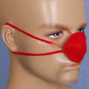 Detail of red handmade crochet nose warmer showing knitted texture and ear loops