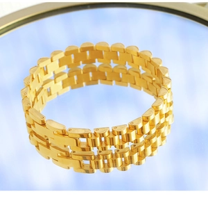 Macro shot of 18K gold plated jubilee style watch band chain on a reflective surface