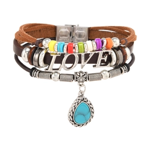 Close-up of multilayer leather bracelet with LOVE metal charm and turquoise droplet pendant