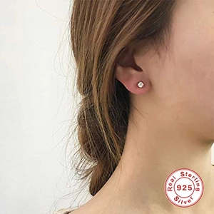 Minimalist S925 sterling silver mini stud earrings set worn by model in a close-up view