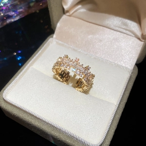 Macro shot of 18k gold plated open ring with cubic zirconia on beige velvet box