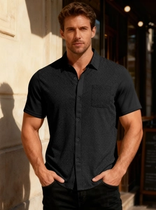 Detail view of men's black short-sleeve shirt featuring textured herringbone knit fabric