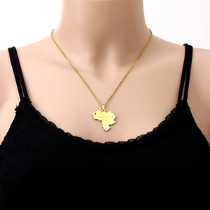 Detail of a gold stainless steel necklace featuring a Venezuela map pendant on a model