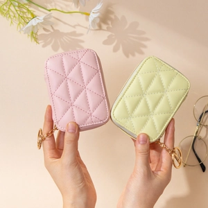Quilted faux leather cosmetic bag in pink and yellow with gold chain and mirror