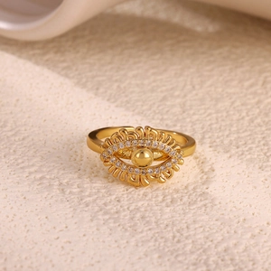Macro detail of a gold adjustable devil eye ring with sunburst zircons on stone surface