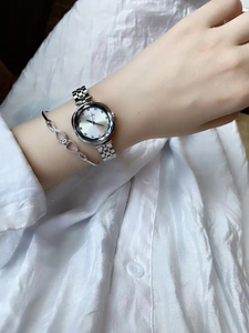 Close-up of elegant silver women watch with rhinestone markers and infinity symbol bracelet