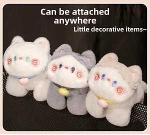 Detailed view of three plush cat dolls with colorful collars and small bells on a dark surface