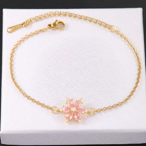 Dettaglio del bracciale in acciaio inossidabile dorato con ciondolo fiore rosa