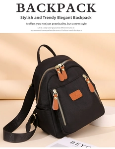 Detailed macro view of black nylon backpack with brown leather tags and golden hardware