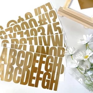 Close-up of 2.5-inch gold foil alphabet stickers with metallic finish and floral decor