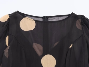 Détail d'une robe en mousseline noire à pois avec encolure et fermeture éclair
