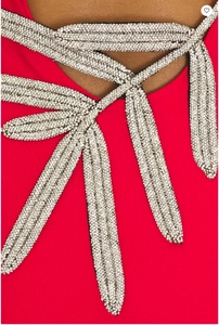 Close-up of sparkling silver rhinestone stripes on red long-sleeve elegant gown fabric