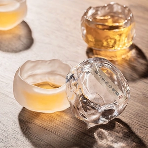Handcrafted Japanese hammered glass tea cup set with frosted finish on a wooden table