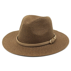 Dettaglio del cappello di paglia marrone scuro con cinturino in pelle e fibbia metallica