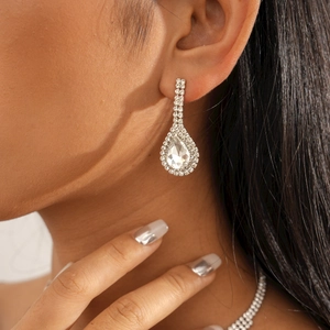Gros plan d'élégantes boucles d'oreilles et collier goutte d'argent avec cristaux brillants