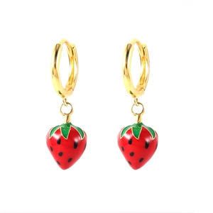 Close-up of red enamel strawberry pendant on gold hoop earrings for women