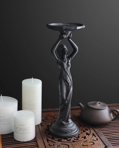 Detailed close-up of a vintage black iron angel candle holder with elegant matte finish