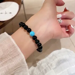 Beaded bracelet with black agate and turquoise stone on model's wrist, vintage style