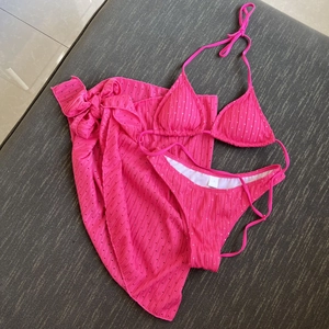 Three-piece rose pink bikini set with halter top, bottom and matching polka dot sarong skirt