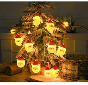 Close-up of Santa Claus LED string lights with warm yellow glow on decorated Christmas tree