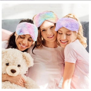 Close-up of three women wearing plush tie-dye sleep masks in macaron gradient colors