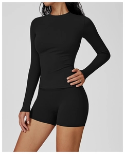 Detailed view of women's black slim-fit yoga set with long sleeve top and athletic shorts