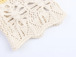 Detail of crochet knit fabric showing intricate hollow floral mesh pattern in cream beige